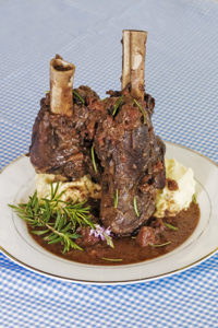 goat shanks on plate with mashed potato
